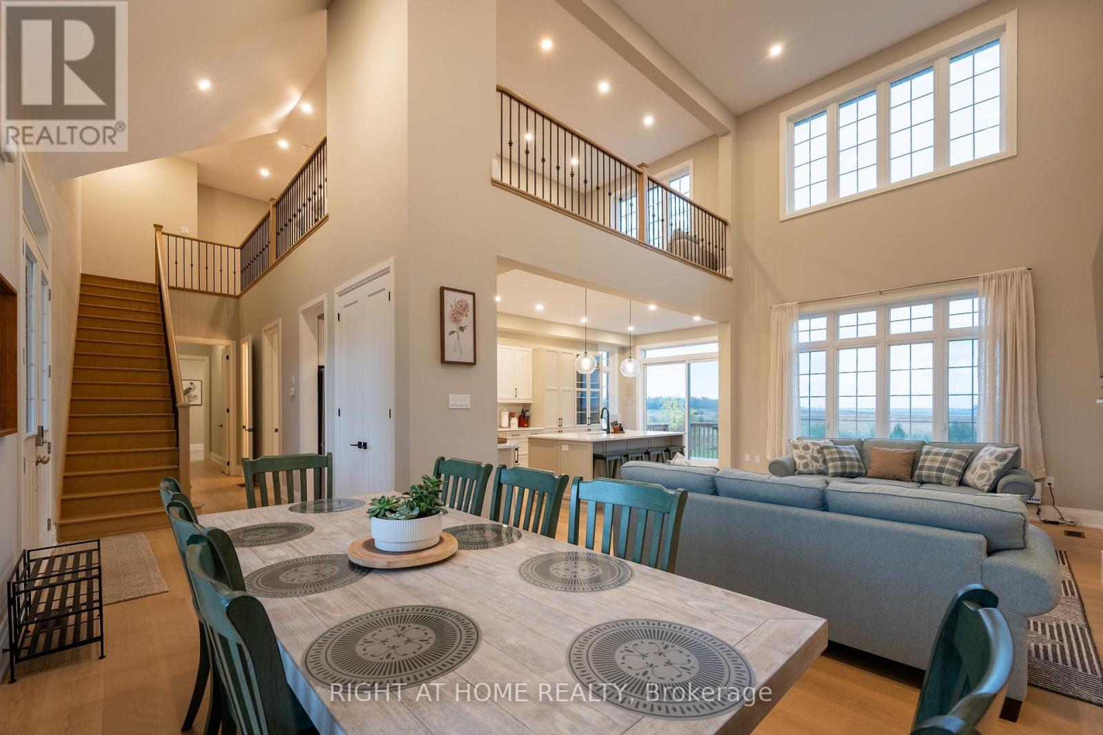 Dining area — staircase to loft, double-height windows