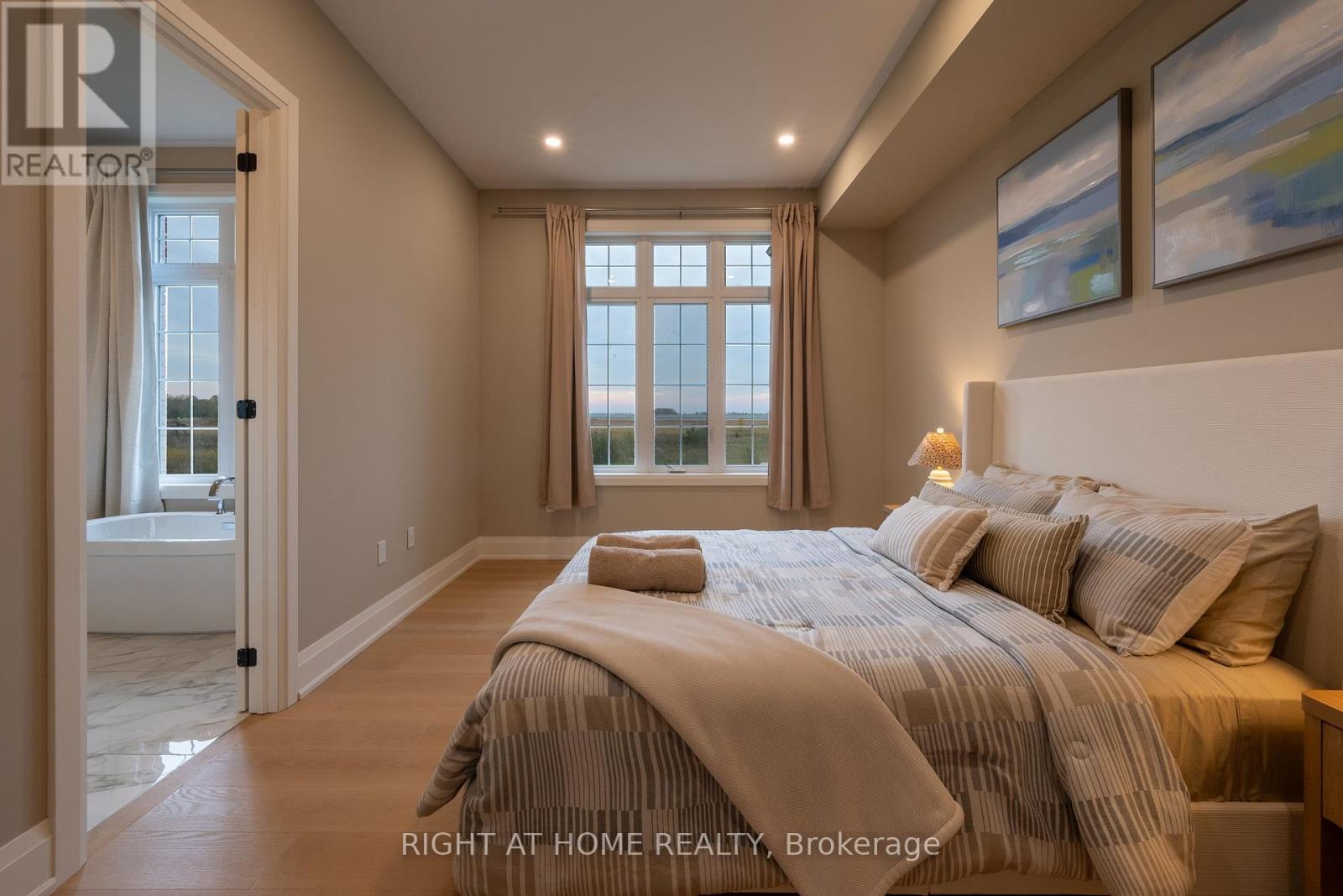 Primary bedroom — tray ceiling, ensuite access, hardwood