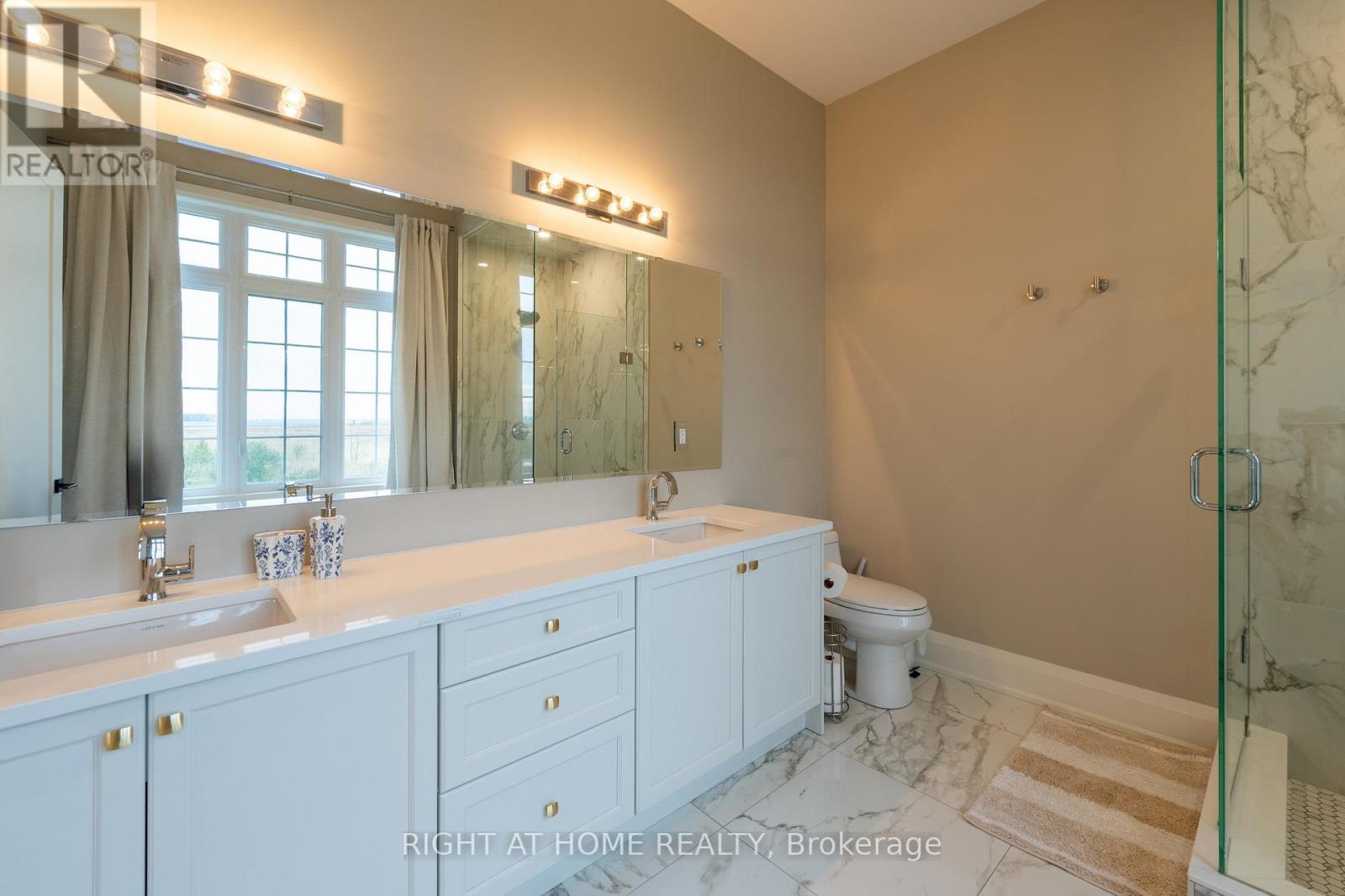Primary ensuite — dual vanity, marble, glass shower