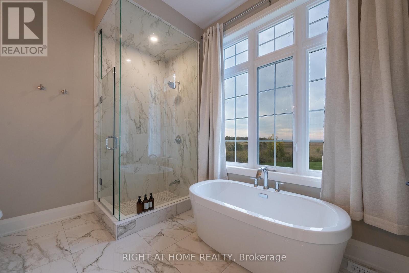 Primary ensuite — freestanding tub, marble tile