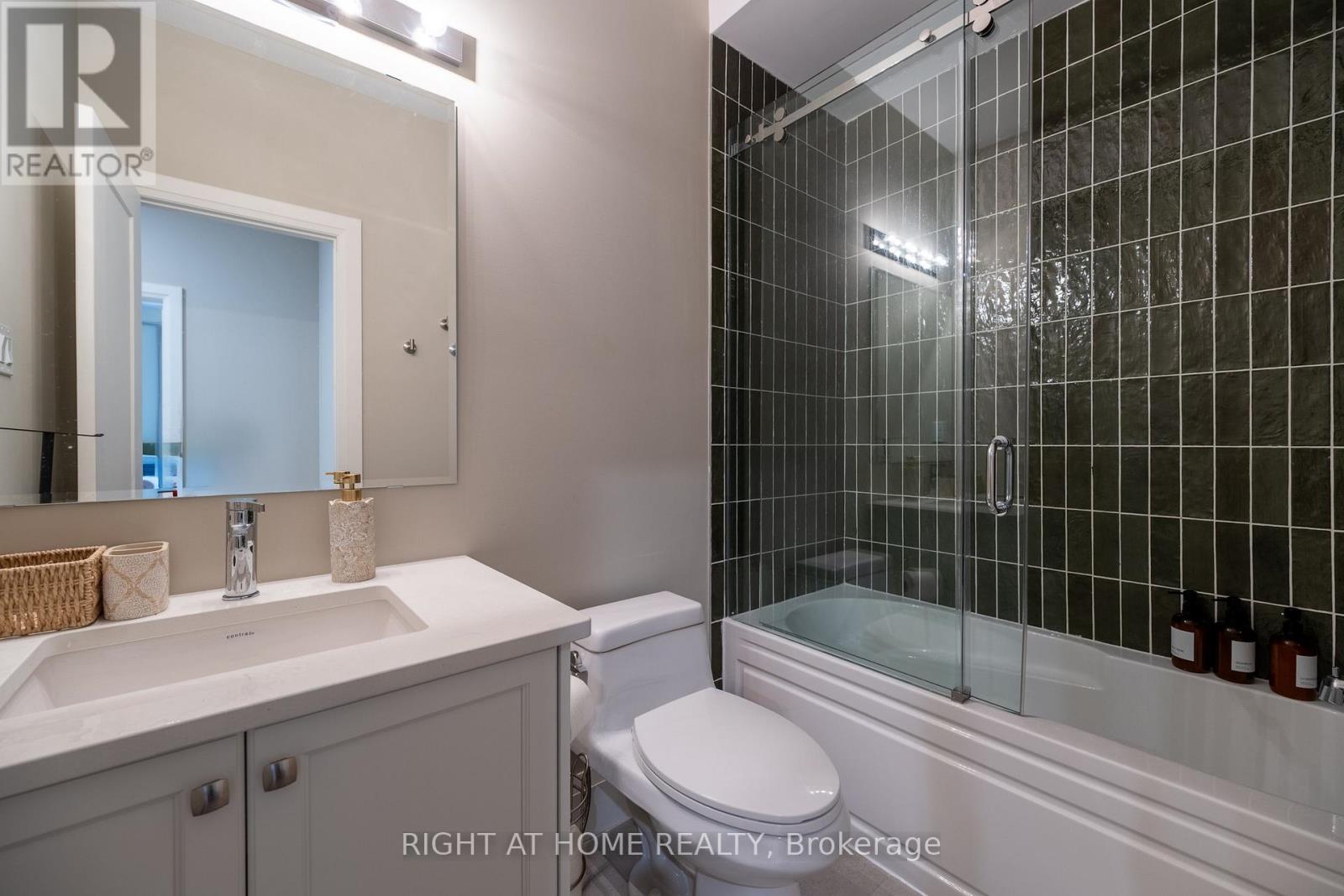 Bathroom — dark tile, tub/shower, glass door
