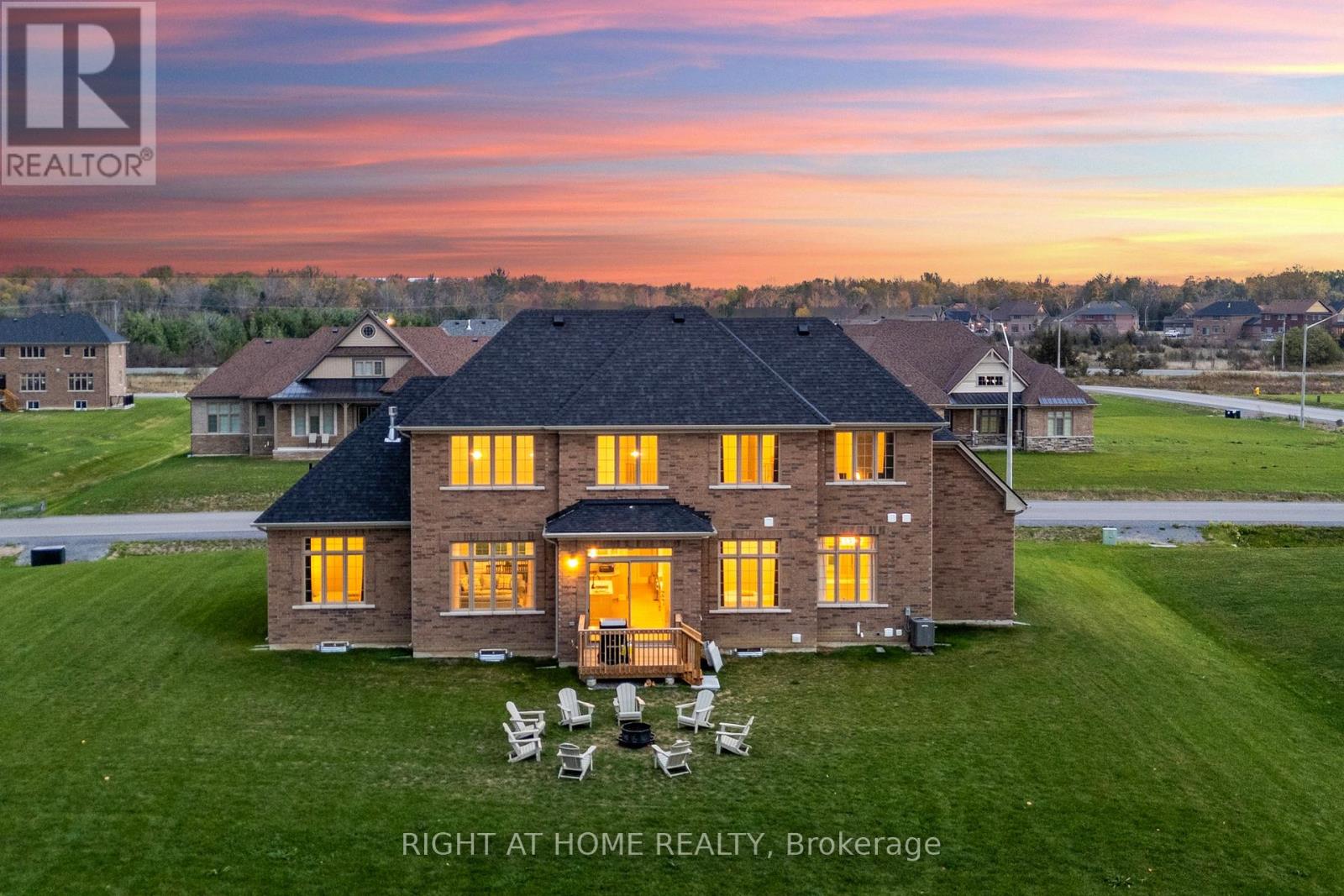 Aerial rear exterior at sunset — deck, fire pit, large yard