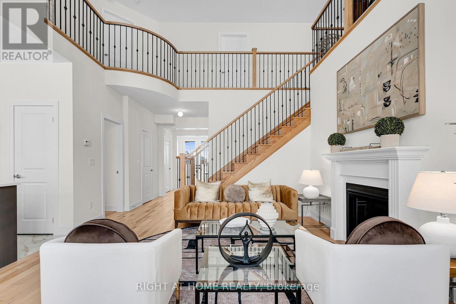 Staged great room — double-height ceilings, fireplace, oak staircase