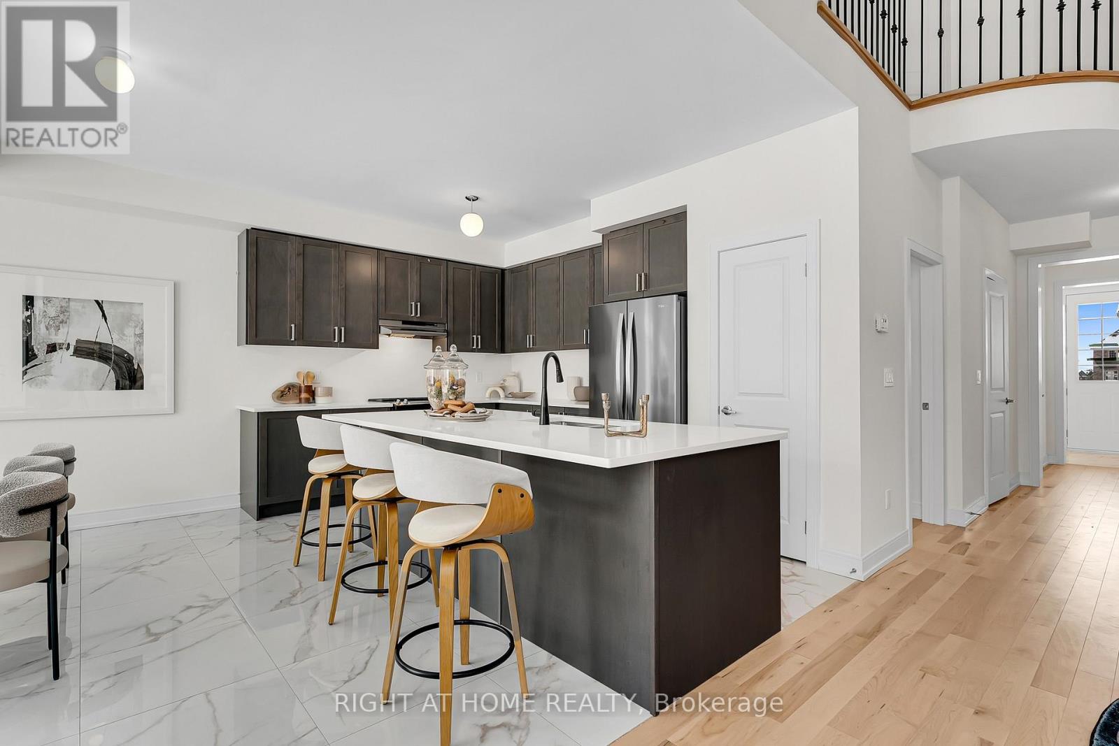 Kitchen — dark cabinetry, quartz island with bar stools